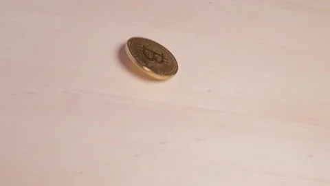 Bitcoin spins in close-up and falls on the table. Market volatility concept Stock Footage 149073510