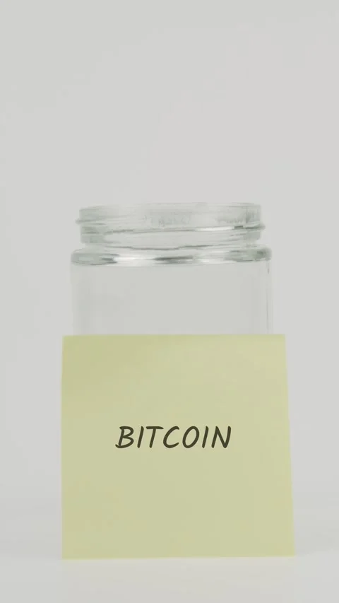 Bitcoin Text or word on yellow sticky note attached to glass jar with hand Stock Footage 311682707
