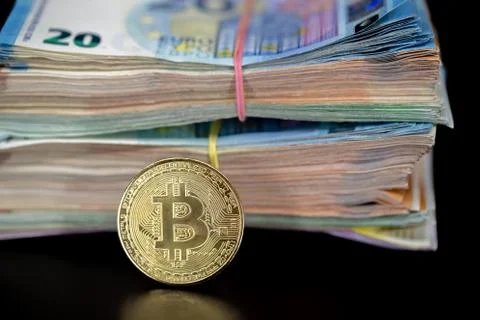 Bitcoin token on black with reflection, with a big pile of euro banknote money Stock Photos