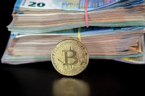Bitcoin token on black with reflection, with a big pile of euro banknote money Stock Photos