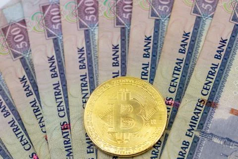 Bitcoin token on top of Dubai, dirham banknotes money. Stock-Fotos