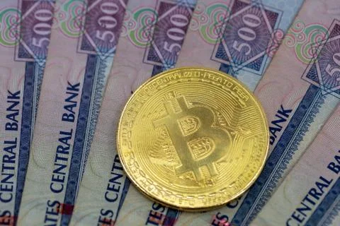 Bitcoin token on top of Dubai, dirham banknotes money. 스톡 사진