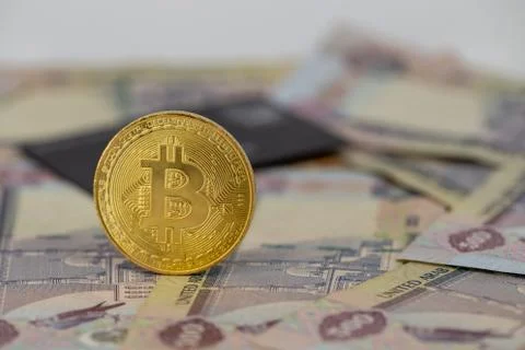 Bitcoin token on top of Dubai, dirham banknotes money with black credit card. Foto stock
