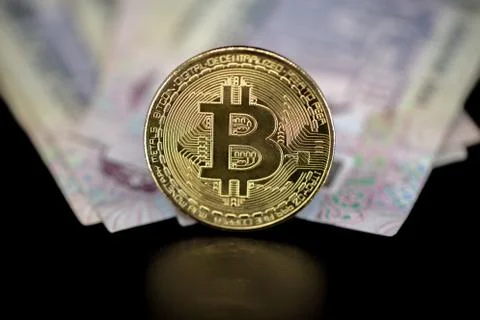 Bitcoin token on top of Dubai, dirham banknotes money Stock Photos