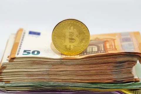 Bitcoin token on white background, on top of many euro banknotes money Stock Photos