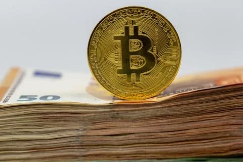 Bitcoin token on white background, on top of many euro banknotes money 스톡 사진