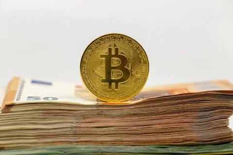 Bitcoin token on white background, on top of many euro banknotes money Stock Photos