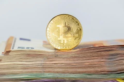 Bitcoin token on white background, on top of many euro banknotes money Stock Photos