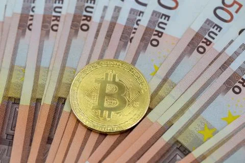 Bitcoin token on white background, on top of many euro banknotes money.  Stock Photos