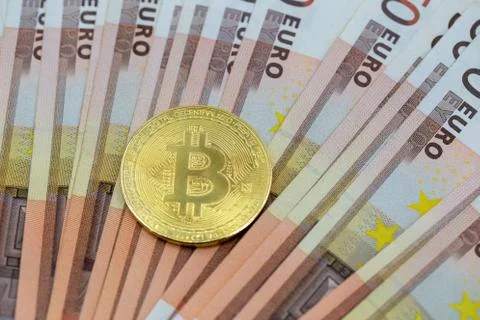 Bitcoin token on white background, on top of many euro banknotes money.  Stock Photos