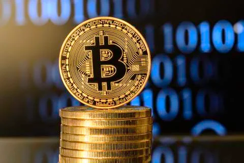 Bitcoin on top of Money stack, against blurry background Stock Photos