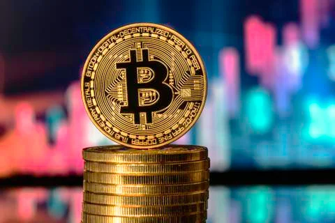 Bitcoin on top of Money stack, against blurry background. Stock Photos