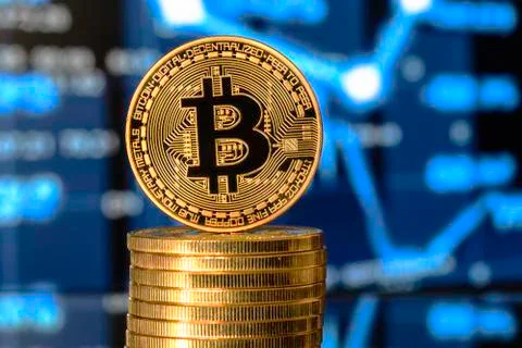 Bitcoin on top of Money stack, against blurry background. Stock Photos