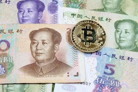 Bitcoin on top of a stack of Renminbi banknotes Stock Photos
