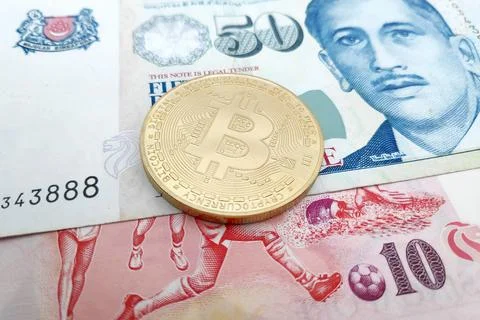 Bitcoin on top of a stack of Singaporean Dollar banknotes Foto stock