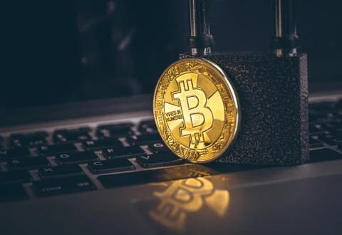 Bitcoin(BTC) coin with padlock on computer background. Stockfoto's