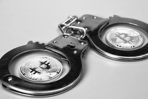 Bitcoins and handcuffs Stock Photos