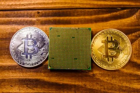Bitcoins and microprocessor on a wooden table. Top view Foto stock