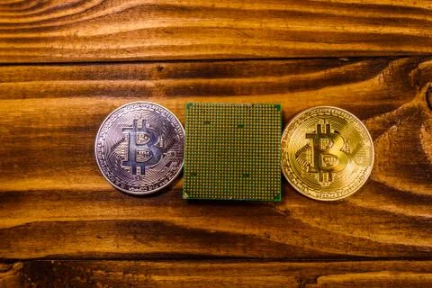 Bitcoins and microprocessor on a wooden table. Top view 스톡 사진
