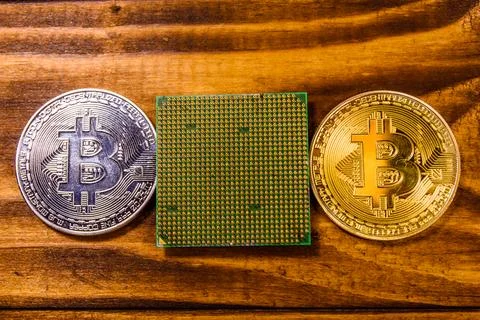 Bitcoins and microprocessor on a wooden table. Top view 写真素材