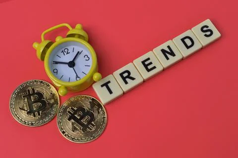 Bitcoins, clock and square letters with text TRENDS. Stock Photos