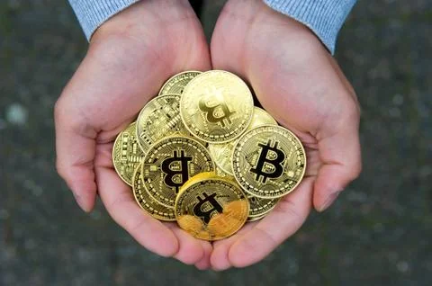 Bitcoins in hands Stock Photos