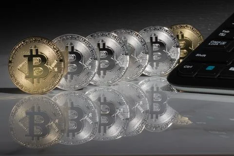 Bitcoins with reflection on marble desk. Electronic money, cryptocurrency. Stock Photos