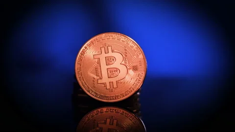 Bitcoins Rotating Slowly with Shallow Depth of Field and Reflection Stock Footage 148312027