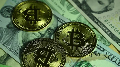 Bitcoins spin on background of dollars and euros Stock Footage 119370624