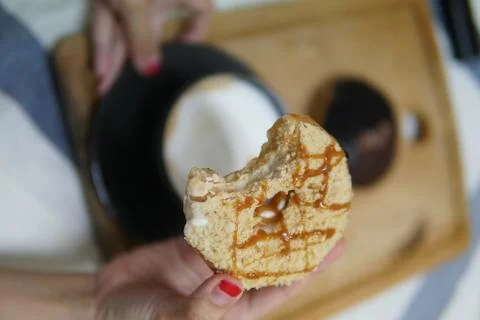 Bite doughnut with coffee at the background Stock Photos