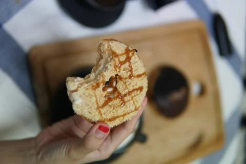 Bite doughnut with coffee at the background Stock Photos