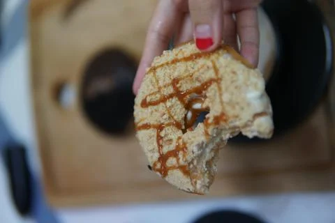 Bite doughnut with coffee at the background Stock Photos