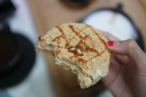 Bite doughnut with coffee at the background Stock Photos