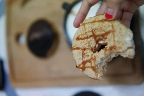 Bite doughnut with coffee at the background Foto stock