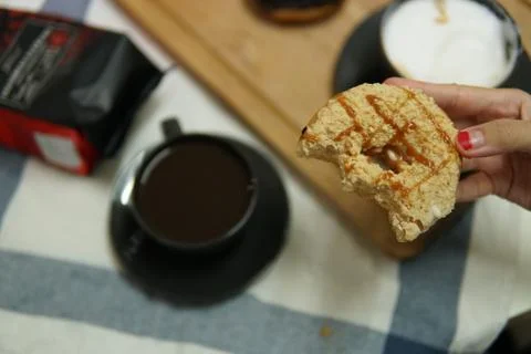 Bite doughnut with coffee at the background Stock Photos