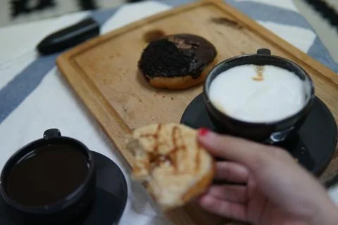 Bite doughnut with coffee at the background Stock Photos