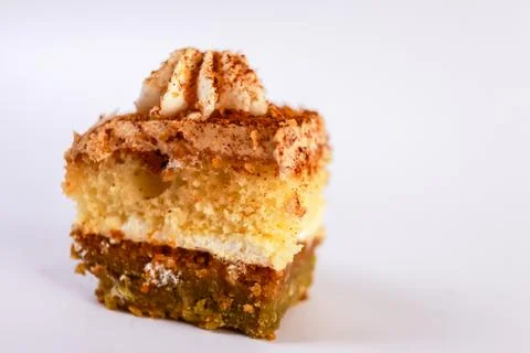 Bite-sized square slice of layered vanilla sponge cake topped with a neat swirl Stock Photos