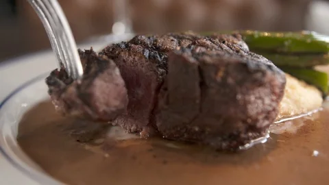 Bite of steak being dipped in sauce  Stock Footage 112575964