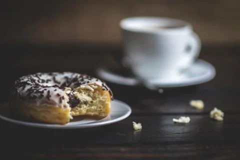 Bite a white donut with chocolate sprinkle Stock Photos