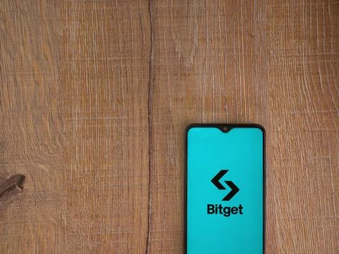 Bitget app launch screen on smartphone on wooden background Stock Photos