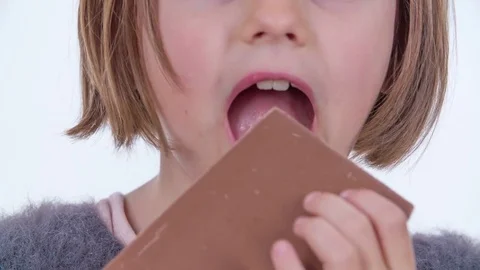 Biting into a big chocolate and hardly breaking it Stock Footage 83725625