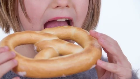 Biting into a large pretzel Stock Footage 83725552