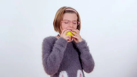 Biting into a pear for her snack Stock Footage 83724681