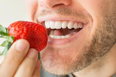 Biting a strawberry Stock Photos