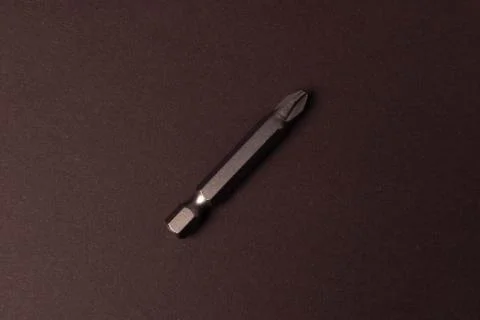 Bits bits for tightening screws of different sizes on a brown background. Stock Photos