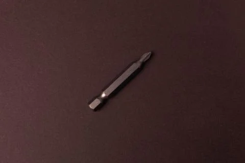 Bits bits for tightening screws of different sizes on a brown background. Foto stock