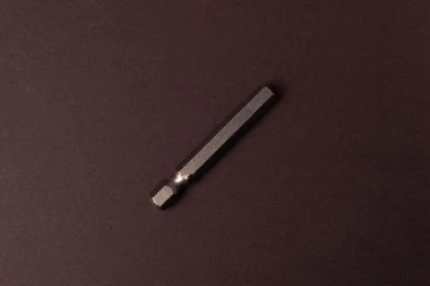 Bits bits for tightening screws of different sizes on a brown background. Stock Photos