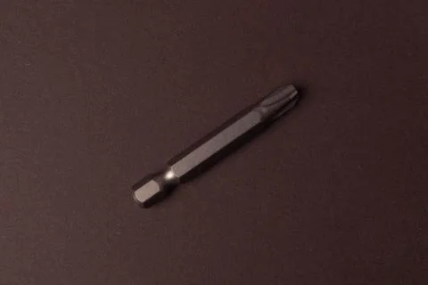 Bits bits for tightening screws of different sizes on a brown background. Stock Photos