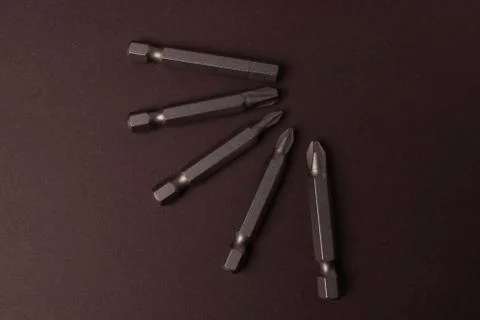 Bits bits for tightening screws of different sizes on a brown background. Foto stock