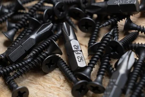 Bits for a screwdriver on a wooden table. macro top view. Stock Photos